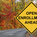 Open Enrollment Ahead sign in fall background