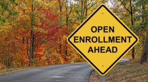 Open Enrollment Ahead sign in fall background